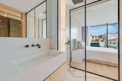 a bathroom with a tub and a shower with glassdoors at Chic Two-Bedroom En Suite in Central Town - Savoy Residence in Funchal
