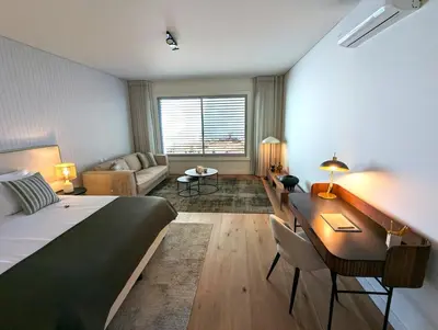 a bedroom with a bed and a desk and a couch at Luxurious Ocean and Sunset Views Family Haven with 3 En-Suite Bedrooms and Pool in Funchal