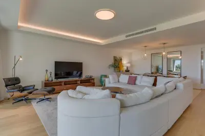 a white living room with a large white couch at Luxurious Ocean and Sunset Views Family Haven with 3 En-Suite Bedrooms and Pool in Funchal