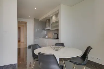 a kitchen with a white table and black chairs at Luxurious Ocean and Sunset Views Family Haven with 3 En-Suite Bedrooms and Pool in Funchal