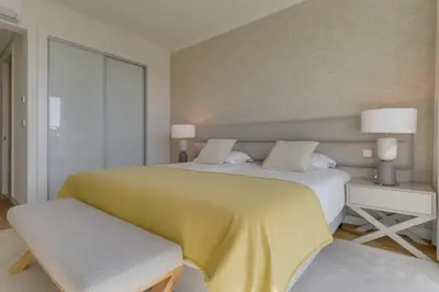 a bedroom with a large bed with a yellow blanket at Luxurious Ocean and Sunset Views Family Haven with 3 En-Suite Bedrooms and Pool in Funchal