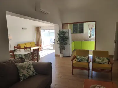 a living room with a couch and a kitchen at MONTE s PEDRO in Lagos