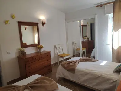 a bedroom with two beds and a dresser and a mirror at MONTE s PEDRO in Lagos