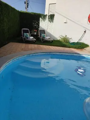a large blue swimming pool with two chairs in a yard at MONTE s PEDRO in Lagos