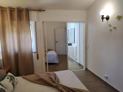 a bedroom with a bed and a hallway with a mirror at MONTE s PEDRO in Lagos