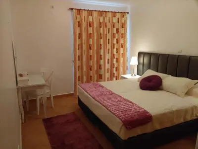 a bedroom with a bed with a table and a window at APARTAMENTOS OASIS BEACh in Lagos