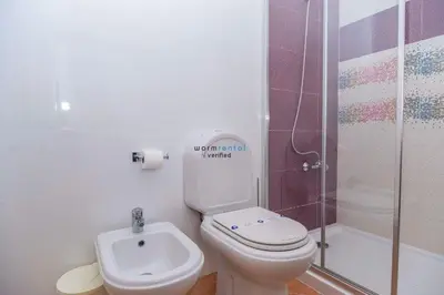 a bathroom with a toilet and a shower and a sink at APARTAMENTOS OASIS BEACh in Lagos