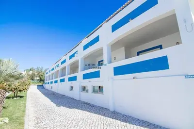 a white building with blue accents on it at APARTAMENTOS OASIS BEACh in Lagos