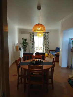 a dining room and living room with a table and chairs at APARTAMENTOS OASIS BEACh in Lagos