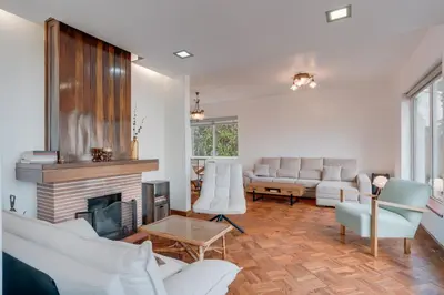 a living room with white furniture and a fireplace at Villa Natural Oasis with panoramic view & bio-diverse 9 950m2 garden in Funchal