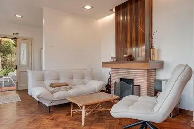 a living room with a white couch and a fireplace at Villa Natural Oasis with panoramic view & bio-diverse 9 950m2 garden in Funchal