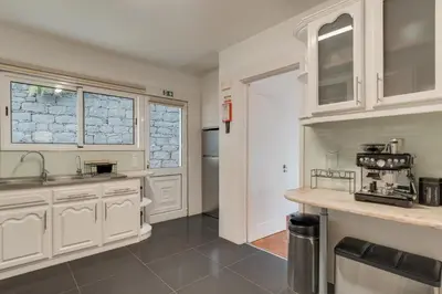 a kitchen with white cabinets and a counter top at Villa Natural Oasis with panoramic view & bio-diverse 9 950m2 garden in Funchal