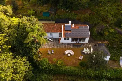 an aerial view of a house with a solar roof at Villa Natural Oasis with panoramic view & bio-diverse 9 950m2 garden in Funchal