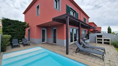 a house with a swimming pool in front of a house at The Red Hot Chill House by LovelyStay in Arco da Calheta