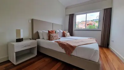 a bedroom with a large bed with a window at The Red Hot Chill House by LovelyStay in Arco da Calheta