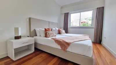 a white bedroom with a large bed with a window at The Red Hot Chill House by LovelyStay in Arco da Calheta