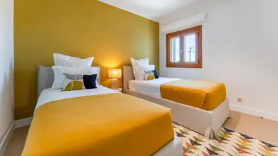 a hotel room with two beds with yellow sheets at Villa Maya Luxurious House With Pool by LovelyStay in Luz
