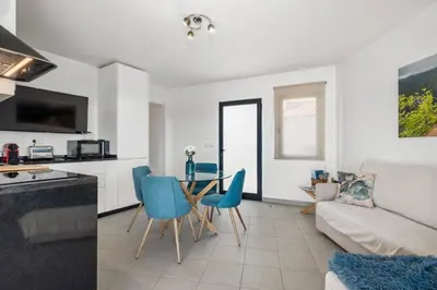 a kitchen and a living room with a table and chairs at Balcoes in Funchal