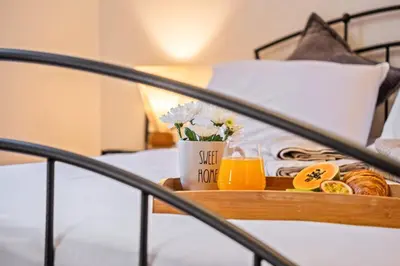 a tray of food and orange juice on a bed at Balcoes in Funchal