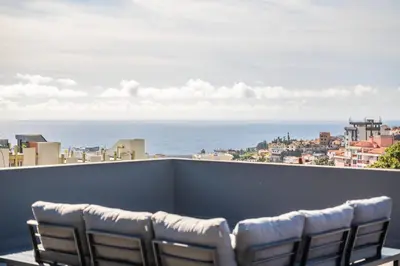 a row of chairs on a balcony overlooking the ocean at Balcoes in Funchal