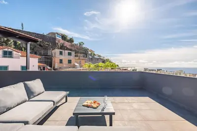 a balcony with a couch and a view of the ocean at Balcoes in Funchal