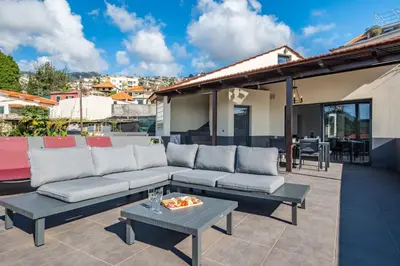 a patio with a couch and a table at Balcoes in Funchal