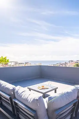 a living room with a couch and a table on a balcony at Balcoes in Funchal