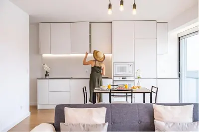 a woman standing in a kitchen in a living room at Penthouse A Fabrica by Homie in Funchal