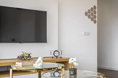 a living room with a tv and a glass table at Penthouse A Fabrica by Homie in Funchal