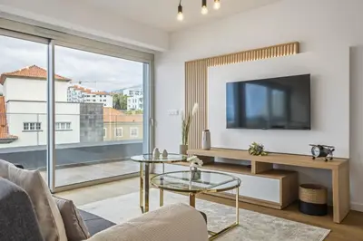 a living room with a tv and a glass table at Penthouse A Fabrica by Homie in Funchal