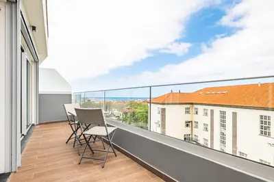 a balcony with chairs and a view of a building at Penthouse A Fabrica by Homie in Funchal