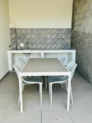 a white table and chairs in front of a wall at Casa Victória in Funchal