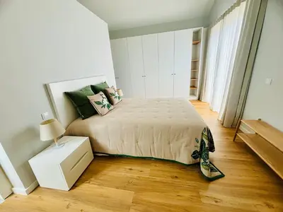 a bedroom with a bed and a wooden floor at Casa Victória in Funchal