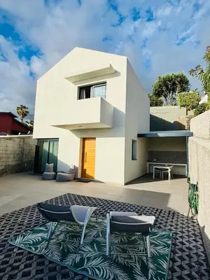 a white house with two chairs on a patio at Casa Victória in Funchal
