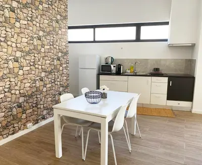 a kitchen with a white table and white chairs at Machico flat center near beach w parking in Machico