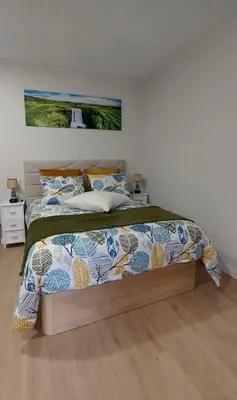a bedroom with a large bed with a comforter and pillows at Bem Me Quer in Caniço