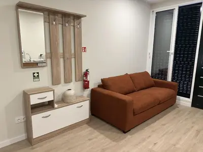 a living room with a brown couch and a mirror at Bem Me Quer in Caniço