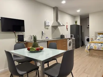 a kitchen and living room with a table and chairs at Bem Me Quer in Caniço