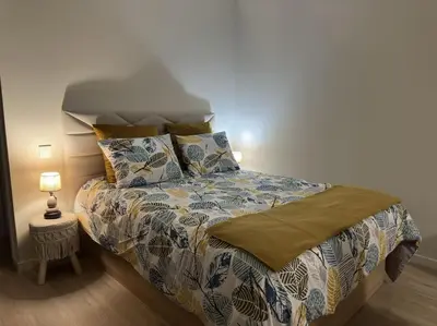 a bedroom with a bed and a lamp on a floor at Bem Me Quer in Caniço