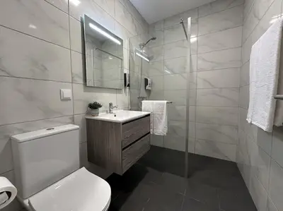 a bathroom with a toilet and a sink and a shower at Bem Me Quer in Caniço