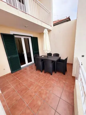 a patio with a table and chairs on a balcony at Villa Abreu in Ponta do Sol