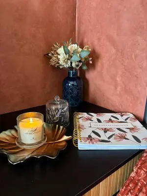 a table with a candle and a book and a vase at Thomas Suite Calheta in Lombada dos Marinheiros