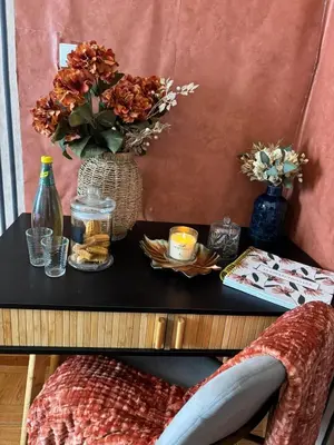 a table with a vase of flowers on a table with a chair at Thomas Suite Calheta in Lombada dos Marinheiros