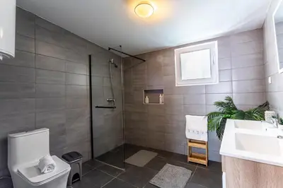 a bathroom with a shower and a toilet and a sink at Thomas Suite Calheta in Lombada dos Marinheiros