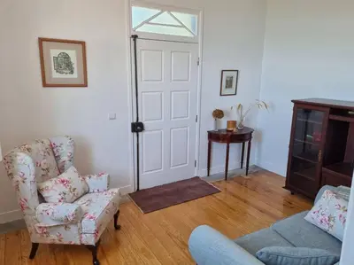 a living room with a couch and a chair and a door at Quiet Countryside Nature Retreat in Santa Cruz