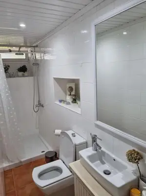 a bathroom with a toilet and a sink and a mirror at Quiet Countryside Nature Retreat in Santa Cruz