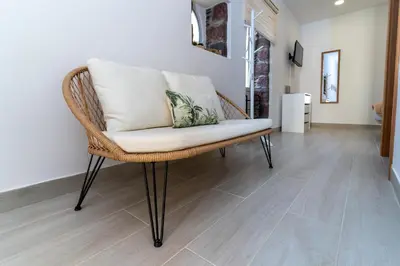 a wicker chair in a room with a wooden floor at Villas Renacer in Paul do Mar