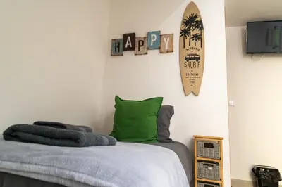 a bedroom with a bed with a green pillow and a surfboard at Villas Renacer in Paul do Mar