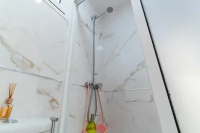 a shower in a bathroom with a white marble wall at Villas Renacer in Paul do Mar