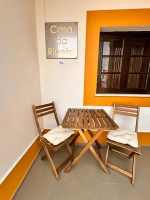 a wooden table and two chairs in a room at Casa da Ribeira in Vila do Bispo